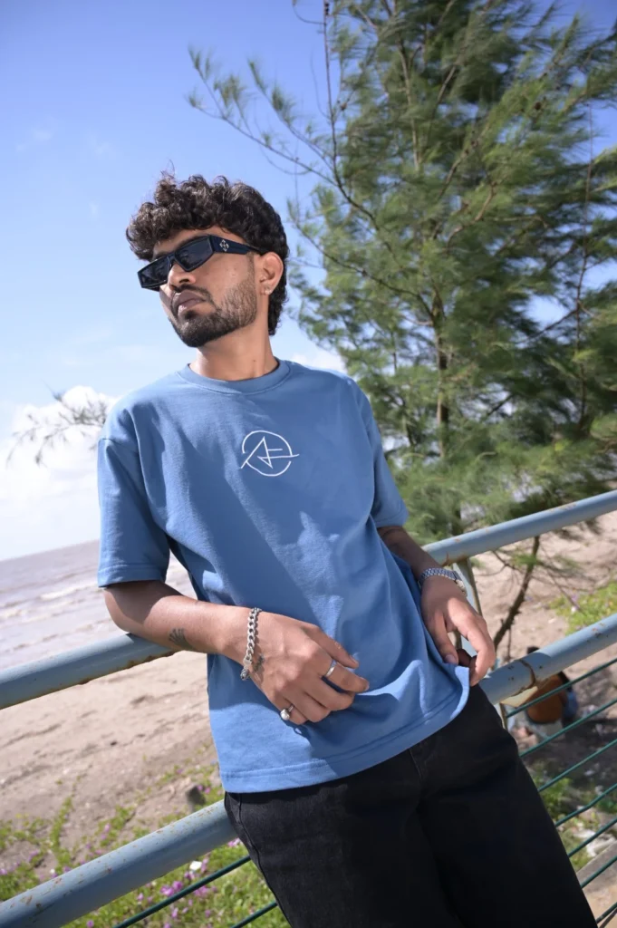 Blue Fenzzicio logo tee at the beach railing